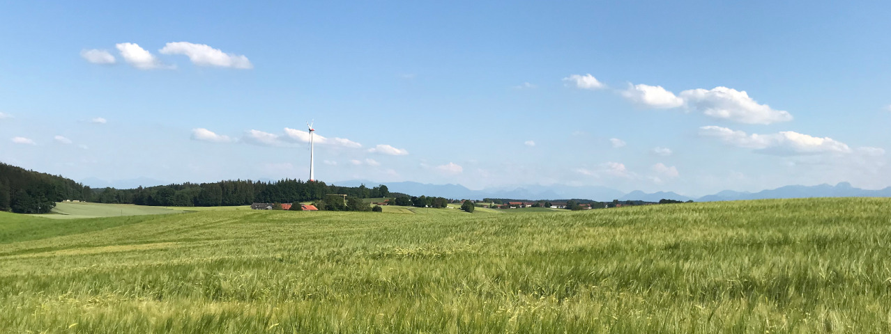 Windkraftanlage bei Alxing vor bayerischem Himmel weiß-bla